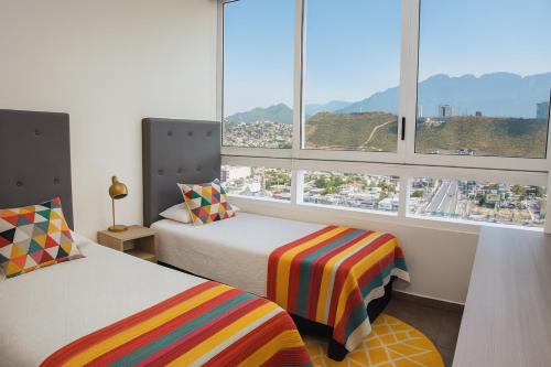 a bedroom with two beds and a large window at Stylish Panoramic Views City Loft in Monterrey