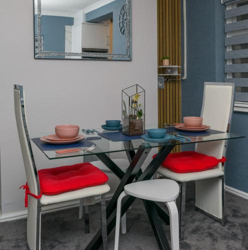 a dining room table with two chairs and a mirror at The Whitehouse M6, Junction 10 With Parking in Walsall
