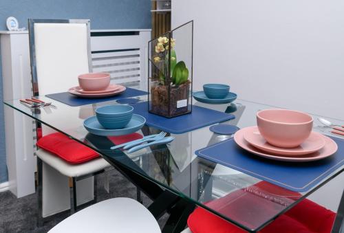 a glass table with plates and bowls on it at The Whitehouse M6, Junction 10 With Parking in Walsall