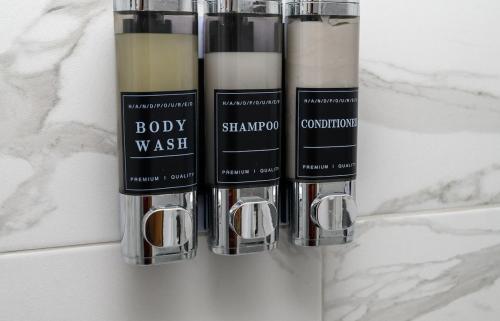 three bottles of body wash sitting on a bathroom counter at The Whitehouse M6, Junction 10 With Parking in Walsall