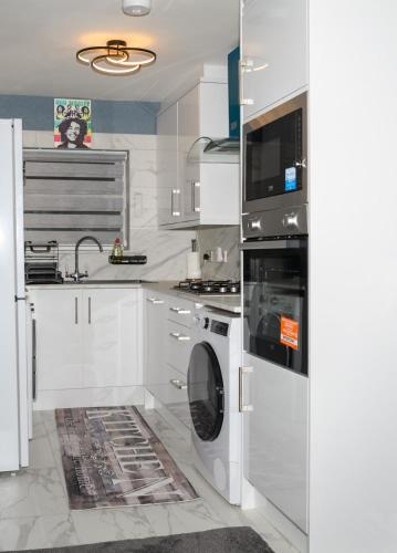 a white kitchen with a washing machine and a sink at The Whitehouse M6, Junction 10 With Parking in Walsall