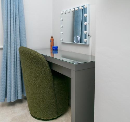 a desk with a green chair and a mirror at The Whitehouse M6, Junction 10 With Parking in Walsall