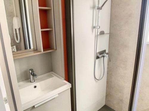une salle de bain avec un lavabo et une douche dans l'établissement Mobil-home 3 chambres avec piscine chauffée, proche plage et commerces - FR-1-361A-16, à Jullouville