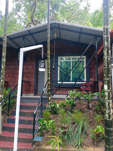 a brick house with stairs leading to the front door at Dandeli palm tree cottages in Dandeli