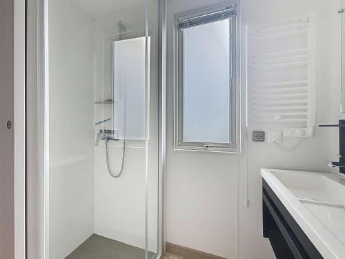 une salle de bain blanche avec une douche et un lavabo dans l'établissement Mobil-home Grand Confort: 2 ch, piscine, plage à 200m, parking, wifi - FR-1-361A-96, à Jullouville