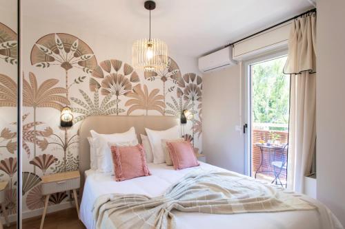 une chambre avec un grand lit avec des oreillers roses dans l'établissement Appartement cosy lumineux avec balcon, à Nice