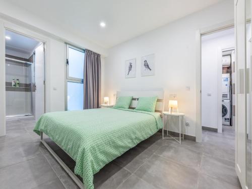 a white bedroom with a green bed and a window at House in Las Palmas near Playa de Las Canteras in Las Palmas de Gran Canaria