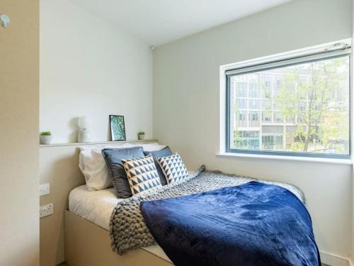 a bedroom with a bed with blue sheets and a window at HFS Redvers Towers Sheffield in Sheffield