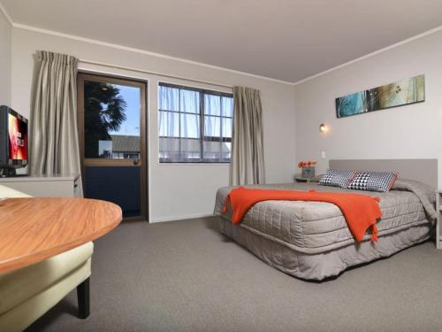 a bedroom with a bed and a large window at Knightsbridge Court Motor Lodge in Blenheim