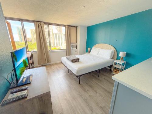 a room with a bed and a television in it at Hawaiian Monarch 1105 condo in Honolulu