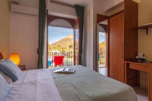a bedroom with a bed with a view of a balcony at Hotel Orsa Maggiore in Vulcano