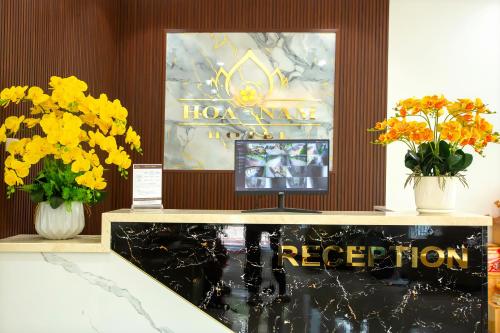 a reception desk with flowers and a sign that reads houston monopoly at Hoa Nam Hotel Việt Hưng in Long Biên