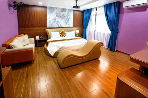 a bedroom with a bed and a couch and a chair at Hoa Nam Hotel Việt Hưng in Long Biên