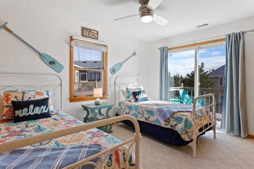 a bedroom with two beds and a window at 8074 - Sea Glass Charmer in Avon