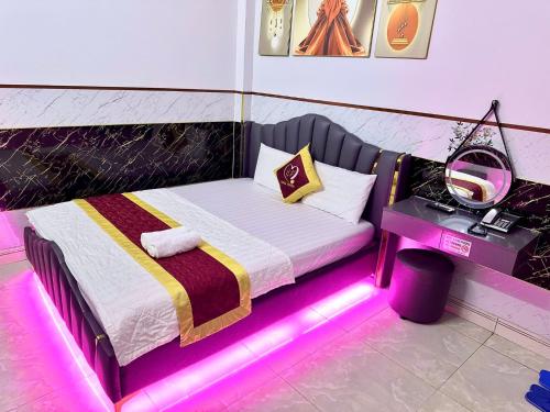 a bedroom with a bed with a pink lighting at Hoàng Phương Hotel Hồ Chí Minh in Ho Chi Minh City