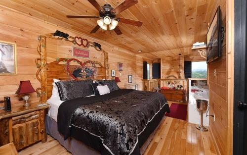 een slaapkamer met een bed en een plafondventilator bij Mountain Romance in Sevierville