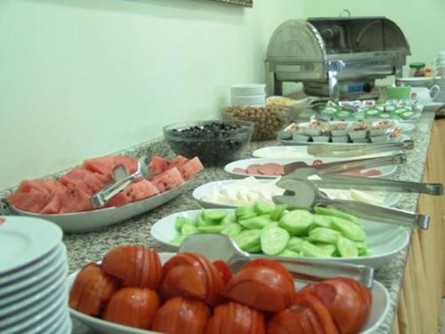 a buffet of food with tomatoes and vegetables on plates at My Solmaz Hotel in Cesme