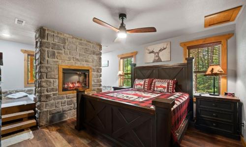 een slaapkamer met een stenen muur, een bed en een open haard bij Rustic Waters in Sevierville