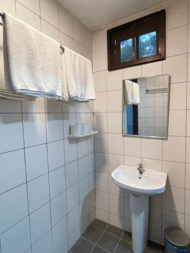a white bathroom with a sink and a mirror at Permai Rainforest Resort in Santubong