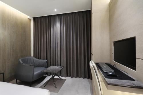a hotel room with a bed and a desk and a television at Hound Hotel Asan Terminal in Asan