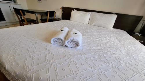 two towels are sitting on top of a bed at Exodus Dandenong Apartment Hotel in Dandenong