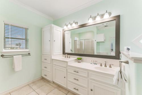 a white bathroom with two sinks and a large mirror at Cute As Shell IPE125 in Padre Island