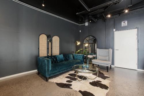 a living room with a green couch and a glass table at Artel Apartments Brunswick in Melbourne