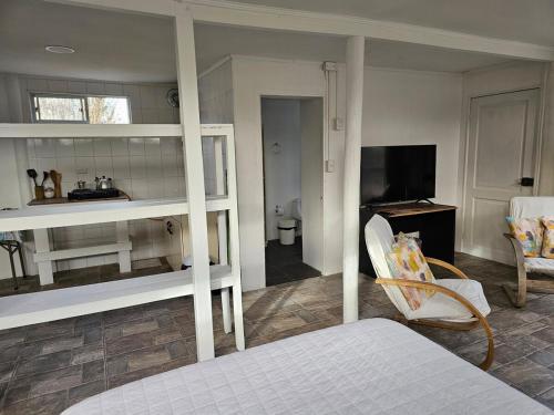 a bedroom with a bed and a room with a television at Piuwkenyeyu in San Vicente de Taguatagua