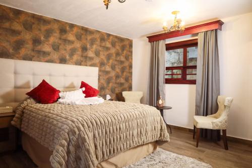 a bedroom with a large bed with red pillows at Hotel Royalinglés in Mineral del Monte