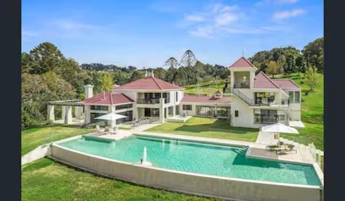 an aerial view of a house with a swimming pool at Maleny Chateau Pool Country Experience, Creek, Gym in Balmoral Ridge
