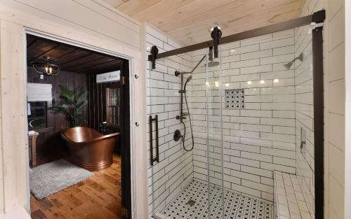a bathroom with a shower with a tub and a sink at On the River in Gatlinburg