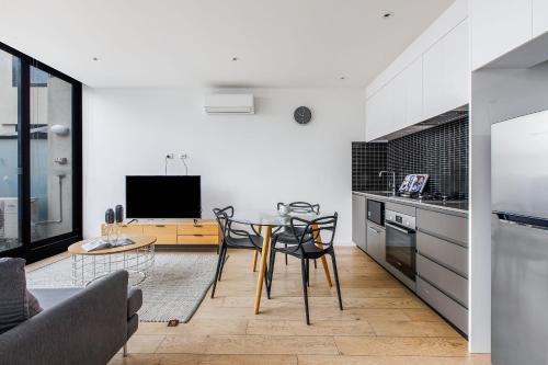a kitchen with a table and chairs in a room at Artel Apartments Brunswick in Melbourne