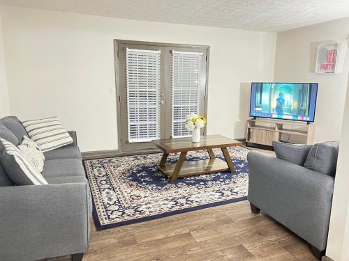 a living room with a couch and a table and a tv at Entire cozy 2-bedroom Guest house in Atlanta in Atlanta