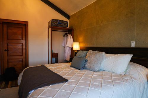 a bedroom with a large bed with pillows on it at Hotel Royalinglés in Mineral del Monte