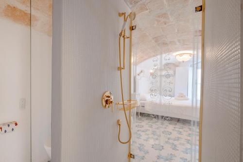 a white bathroom with a shower and a bedroom at Luxury Palazzo Principessa - Elegance and History in Center in Monopoli