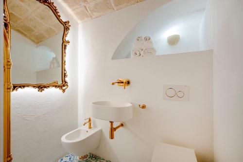 a white bathroom with a mirror and a sink at Luxury Palazzo Principessa - Elegance and History in Center in Monopoli