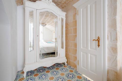 a hallway with a mirror and a room with a bed at Luxury Palazzo Principessa - Elegance and History in Center in Monopoli