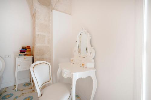 a white dressing table with a mirror and a chair at Luxury Palazzo Principessa - Elegance and History in Center in Monopoli
