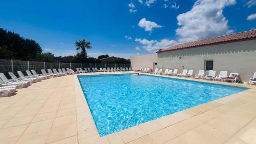 une piscine avec des chaises et un bâtiment dans l'établissement La villa De Lina 416 -Self Check In, à Gallargues-le-Montueux