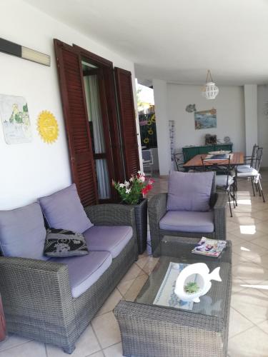 a living room with a couch and chairs and a table at villa andrea in Costa Rei