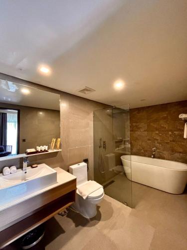 a bathroom with a sink and a toilet and a tub at Altabriza Resort Boracay in Boracay