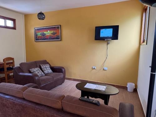 a living room with a couch and a flat screen tv at Villas JABEL TINAMIT in Panajachel