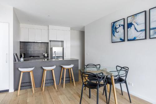 a kitchen with a table and chairs and a counter at Artel Apartments Brunswick in Melbourne