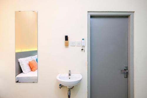 un baño con lavabo y espejo en Sans Hotel Triplets Jogja Expo Center, en Demangan