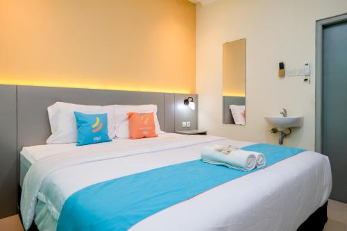 Cama o camas de una habitación en Sans Hotel Triplets Jogja Expo Center