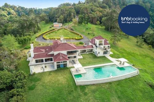 an aerial view of a large house with a swimming pool at Maleny Chateau Pool Country Experience, Creek, Gym in Balmoral Ridge