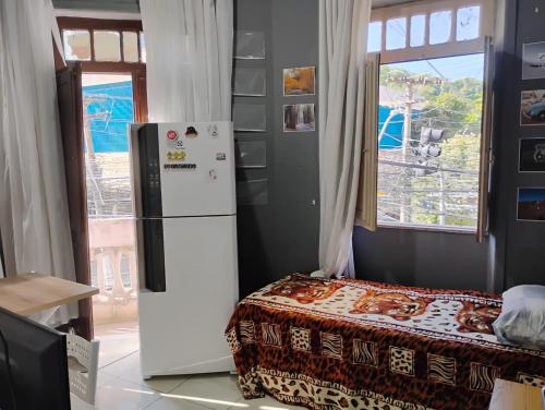 a white refrigerator in a room with a bed at Hostel vila nova in Niterói