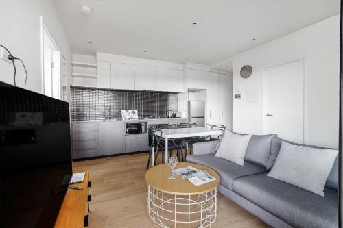 a living room with a couch and a table at Artel Apartments Brunswick in Melbourne