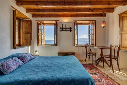 - une chambre avec un lit, une table et des fenêtres dans l'établissement Malvasia Traditional Hotel, à Monemvasia