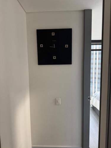 a television on the wall of a room with a bed at Hermoso Apartamento Equilibrium 1509 in Bogotá